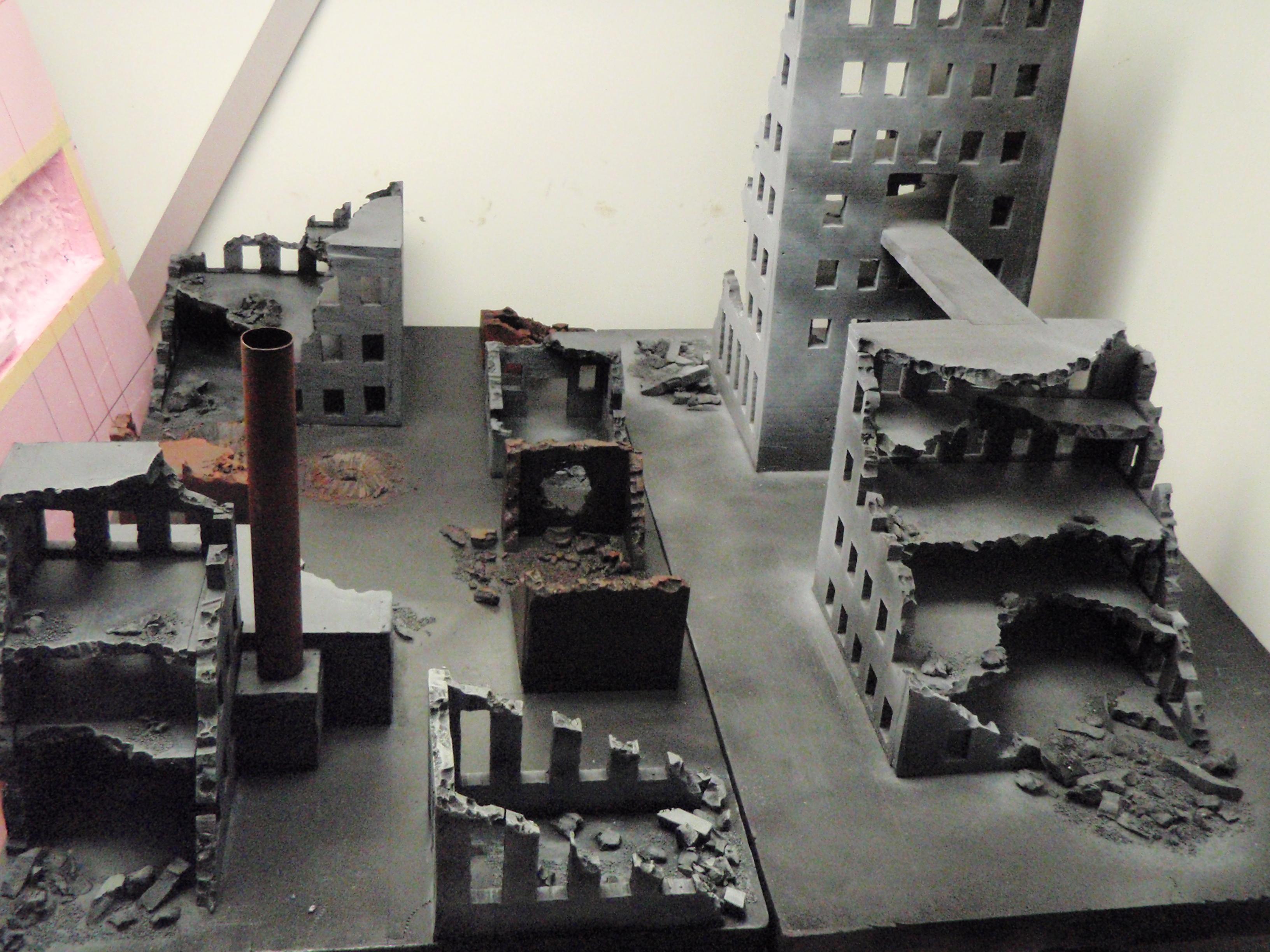 On the left, hand painted buildings.  On the right, painted with a dusting of gray spraypaint