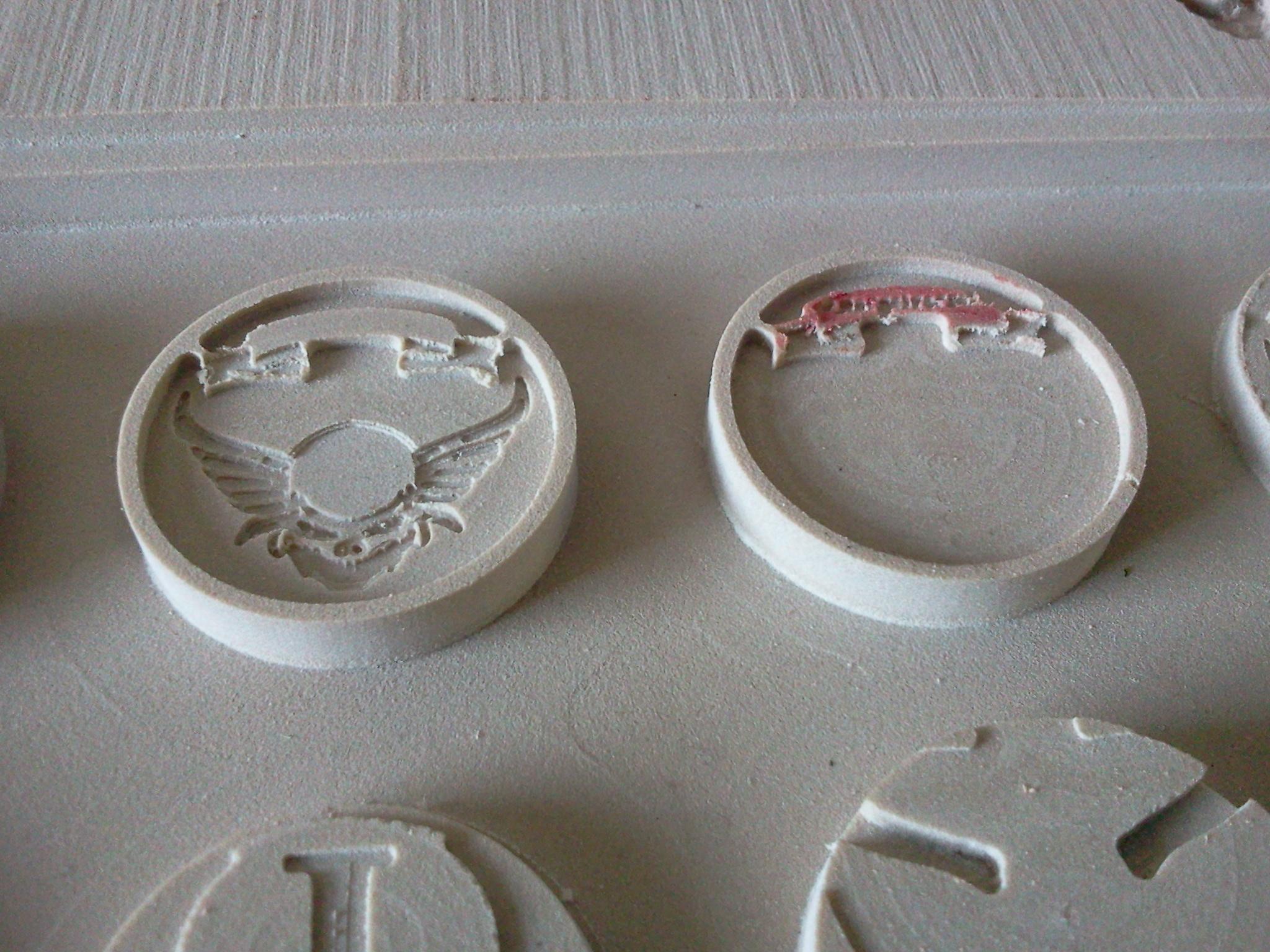 3D scrolls cut on the CNC. The disks are 25mm base size. We found that using a 10 degree engraving bit at the end gives a nice bevel