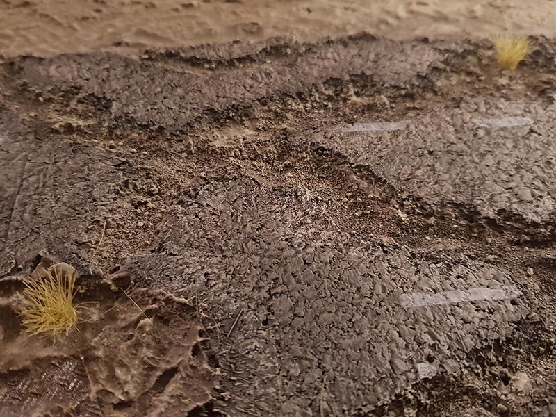 Grass tufts randomly added to cracks in the roadway