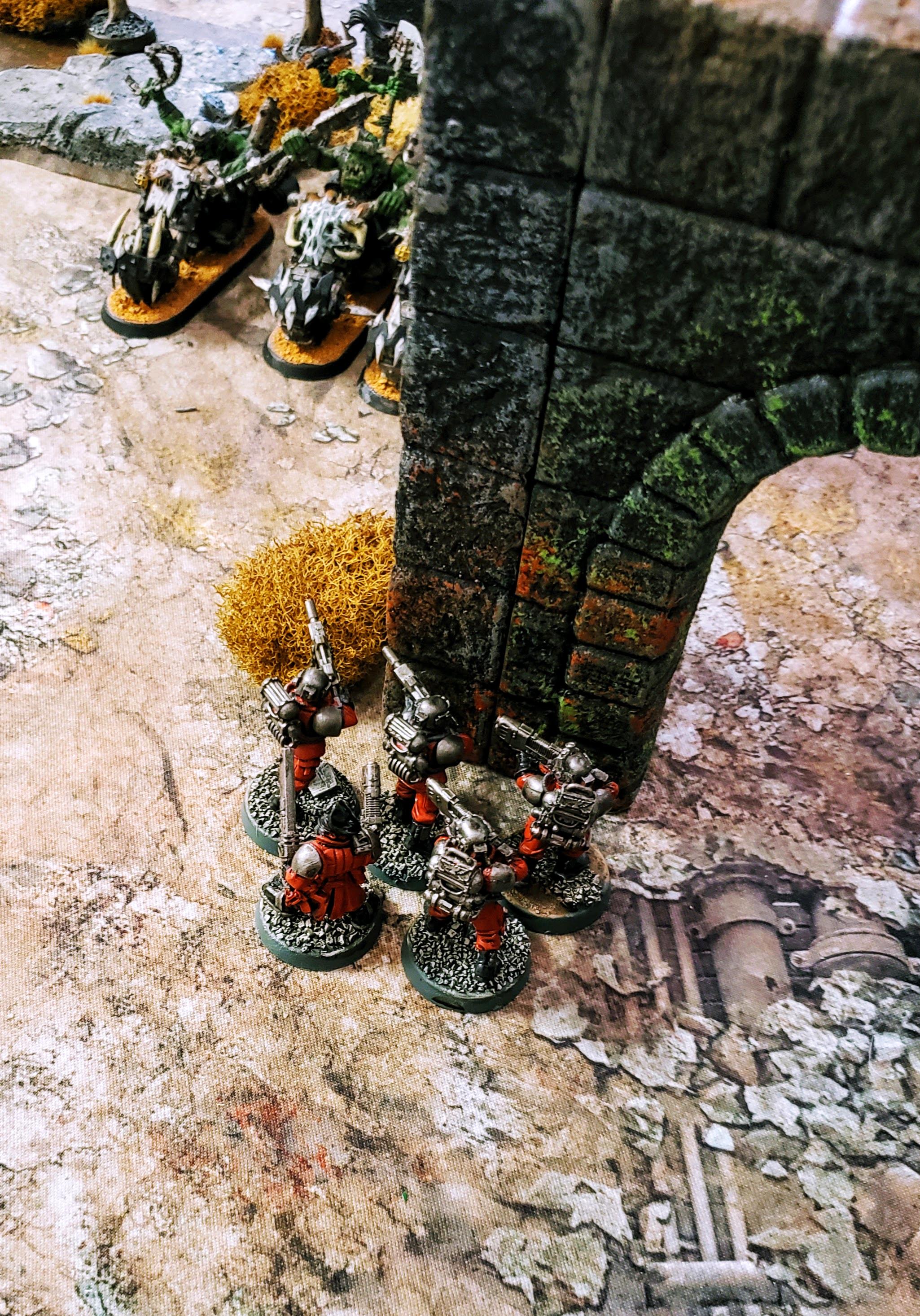 A squad of Inquisitorial Stormtroopers lie in wait for the Ork Warbikes to round the corner